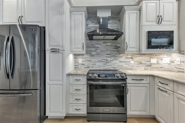 kitchen featuring wall chimney range hood, tasteful backsplash, light stone countertops, and stainless steel appliances