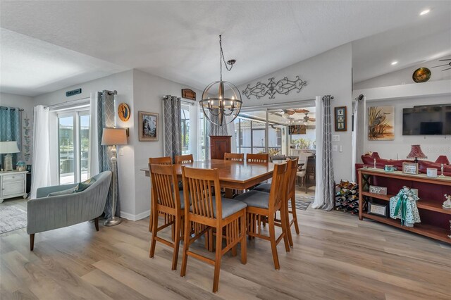 dining space with a notable chandelier, light hardwood / wood-style flooring, and lofted ceiling