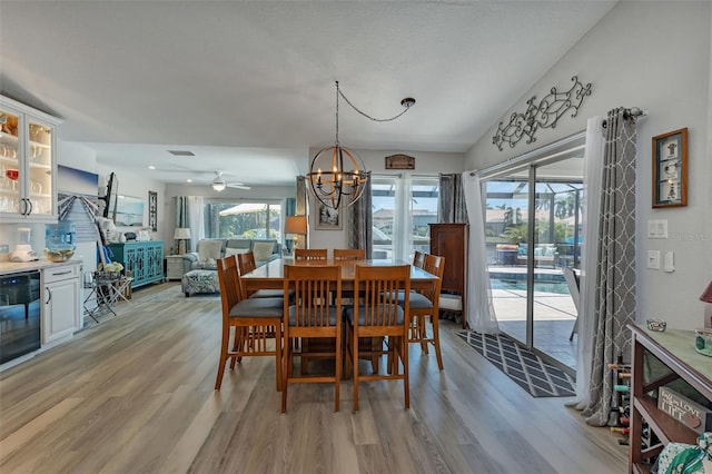 dining room featuring light hardwood / wood-style floors and ceiling fan with notable chandelier