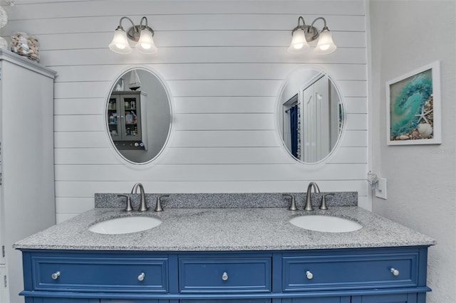 bathroom featuring wooden walls and dual vanity