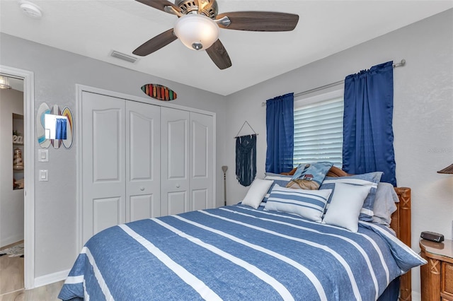 bedroom with ceiling fan, a closet, and hardwood / wood-style flooring