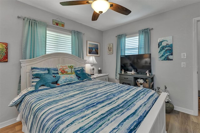 bedroom with ceiling fan, multiple windows, and light wood-type flooring