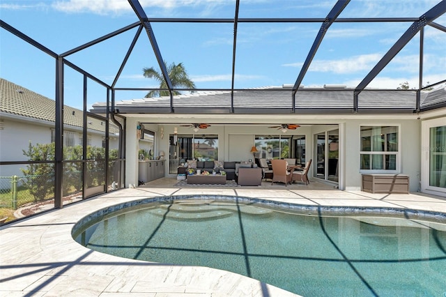 view of pool with glass enclosure, ceiling fan, outdoor lounge area, and a patio