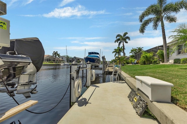 dock area with a water view and a yard