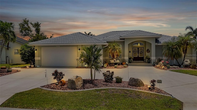 view of front of house with a garage and a yard