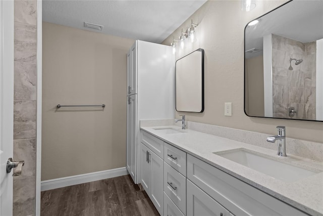 bathroom featuring hardwood / wood-style flooring, vanity, and a textured ceiling