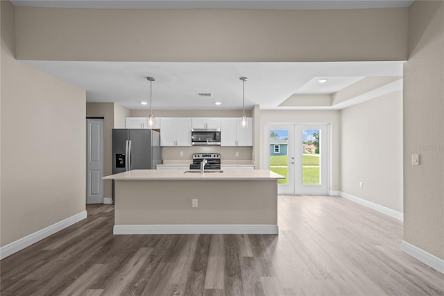 kitchen featuring white cabinetry, sink, hanging light fixtures, an island with sink, and appliances with stainless steel finishes