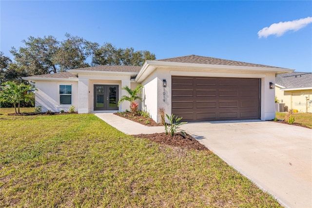 view of front of home featuring french doors, cooling unit, a front yard, and a garage