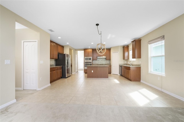 kitchen featuring light tile patterned floors, sink, stainless steel appliances, and a kitchen island