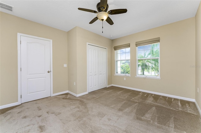 unfurnished bedroom with a closet, ceiling fan, and carpet