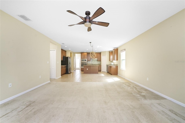 unfurnished living room featuring light colored carpet and ceiling fan