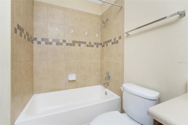 full bathroom featuring toilet, tiled shower / bath combo, and vanity