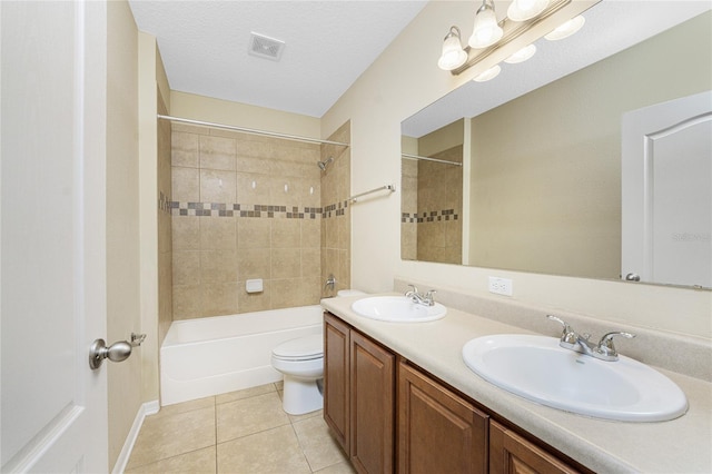 full bathroom featuring toilet, tile patterned flooring, vanity, a textured ceiling, and tiled shower / bath combo