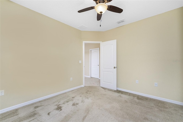 carpeted spare room with ceiling fan