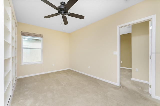 empty room featuring ceiling fan and light carpet