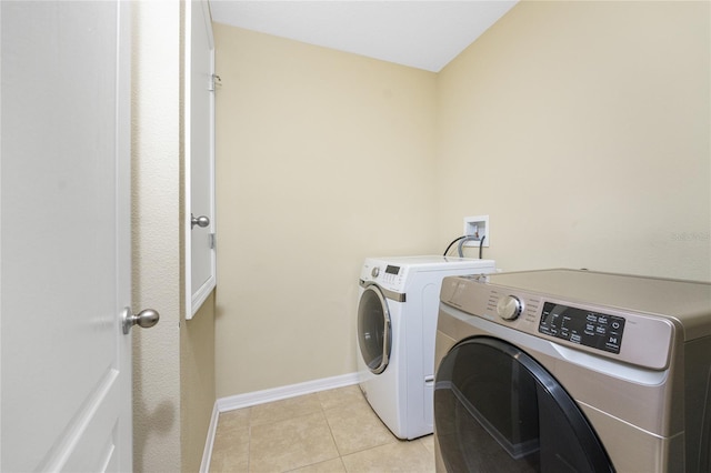 clothes washing area featuring light tile patterned floors and independent washer and dryer