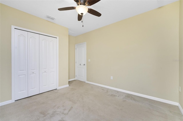 unfurnished bedroom with carpet flooring, ceiling fan, and a closet