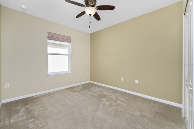 carpeted spare room with ceiling fan