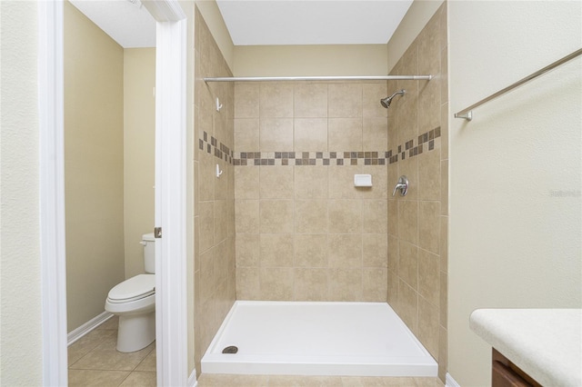 bathroom with tile patterned flooring, toilet, vanity, and tiled shower