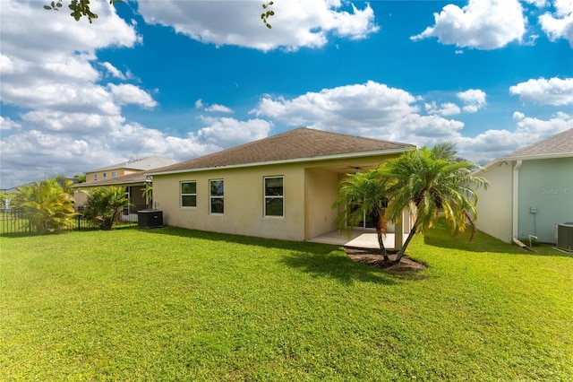 back of property featuring a lawn, cooling unit, and a patio area