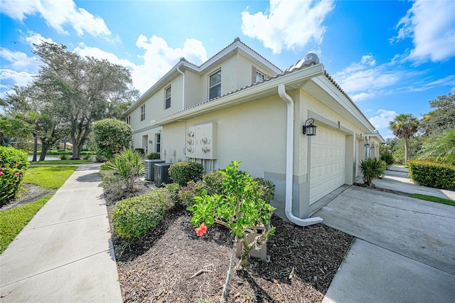 view of home's exterior with a garage and cooling unit