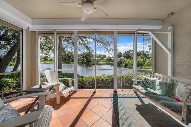 sunroom featuring a water view and ceiling fan