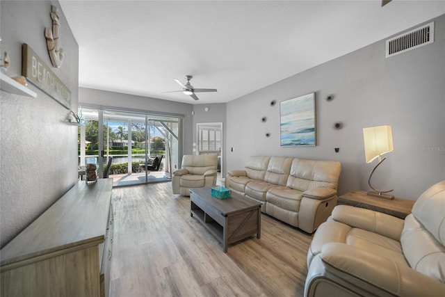 living room with light hardwood / wood-style flooring and ceiling fan