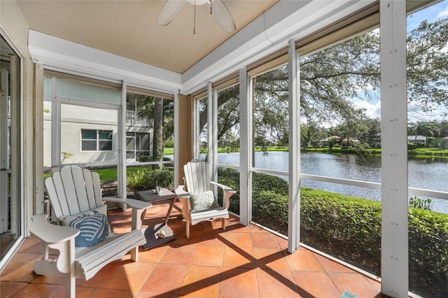 sunroom featuring a healthy amount of sunlight, ceiling fan, and a water view