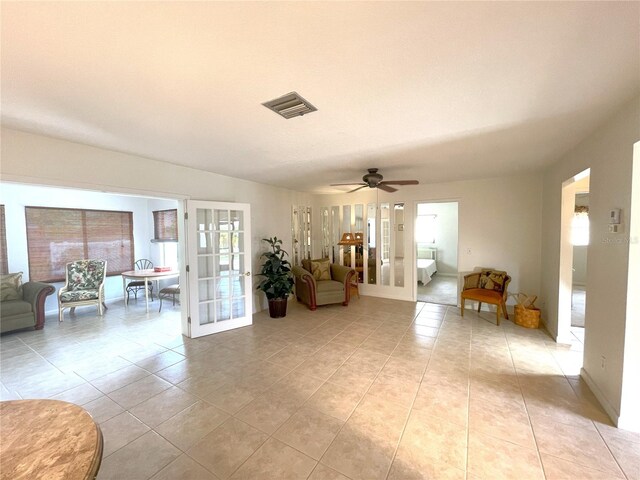 living room featuring ceiling fan, french doors, light tile patterned flooring, and a healthy amount of sunlight