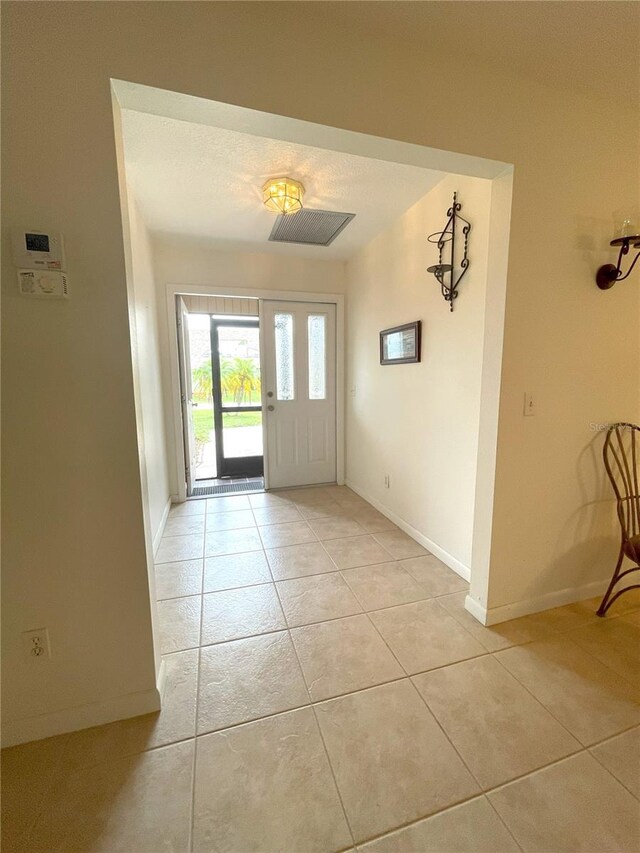 tiled foyer entrance featuring a textured ceiling