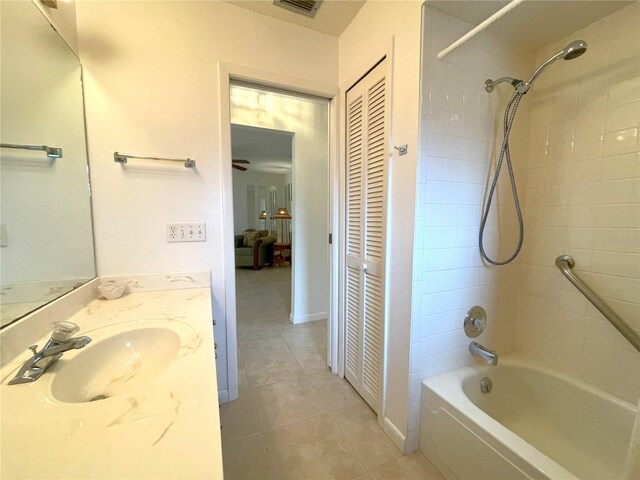 bathroom with tile patterned floors, tiled shower / bath combo, and vanity