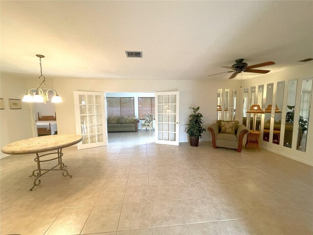 tiled living room with french doors and ceiling fan with notable chandelier