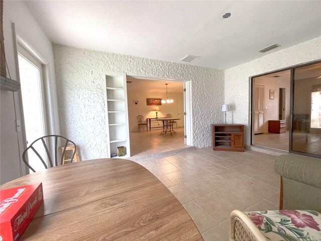 tiled dining area featuring a notable chandelier