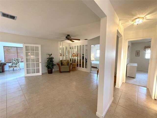 interior space featuring light tile patterned flooring, plenty of natural light, and ceiling fan