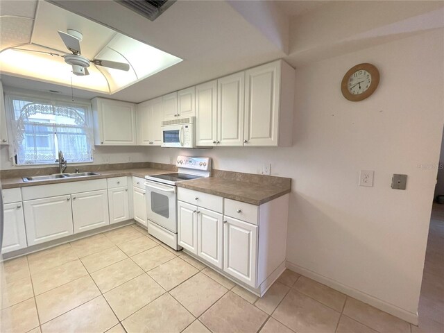 kitchen featuring white cabinetry, sink, light tile patterned flooring, and white appliances