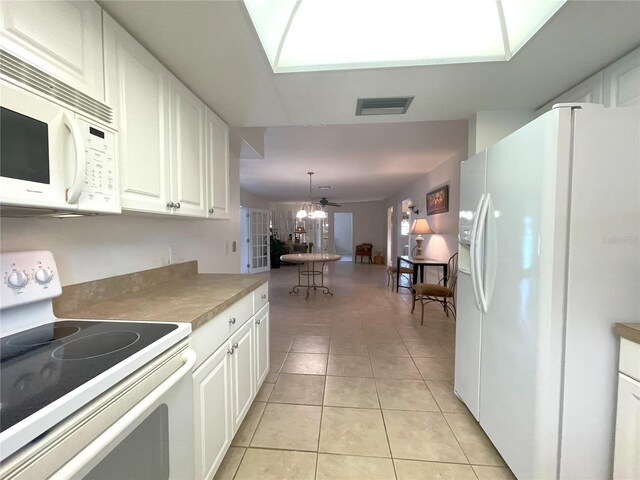 kitchen featuring pendant lighting, white appliances, white cabinets, ceiling fan, and light tile patterned floors