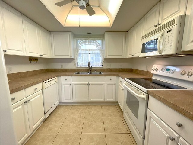 kitchen with white cabinets, light tile patterned floors, white appliances, and sink