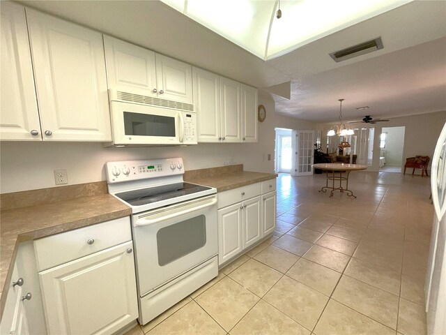 kitchen featuring white cabinets, white appliances, hanging light fixtures, and light tile patterned flooring