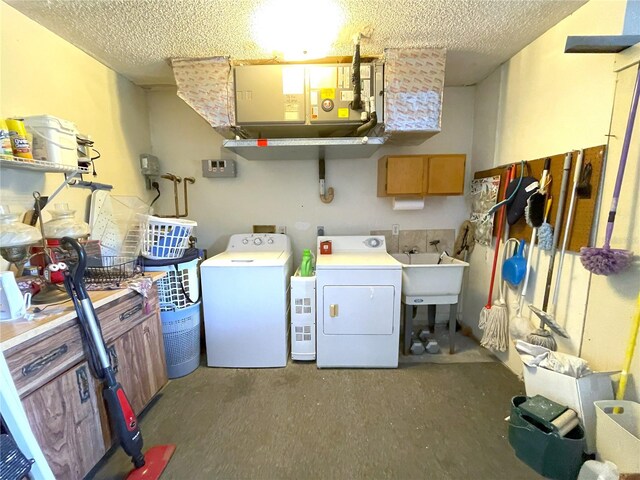 washroom featuring sink, cabinets, independent washer and dryer, and a textured ceiling