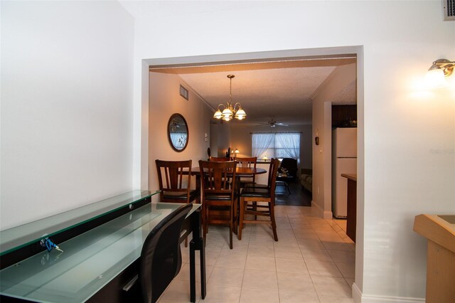 dining room with a textured ceiling, ceiling fan with notable chandelier, and light tile patterned flooring