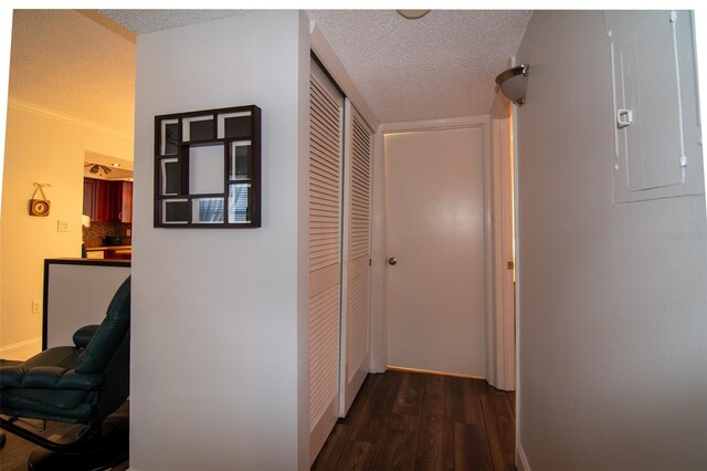 hall featuring a textured ceiling, electric panel, dark hardwood / wood-style floors, and crown molding