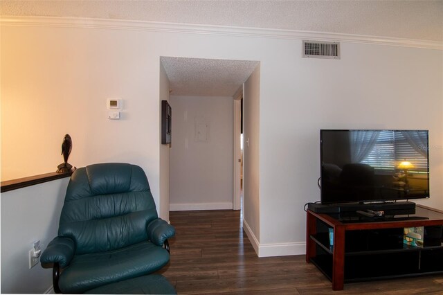 living room featuring a textured ceiling, dark hardwood / wood-style floors, and ornamental molding