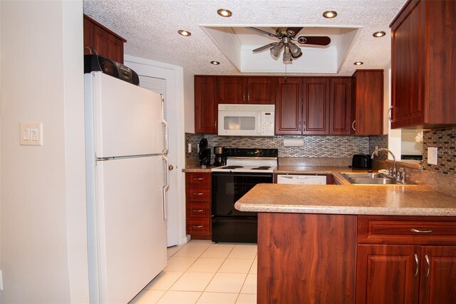 kitchen with sink, kitchen peninsula, a textured ceiling, white appliances, and a tray ceiling