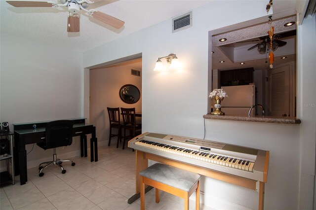 misc room with ceiling fan, sink, light tile patterned flooring, and a textured ceiling