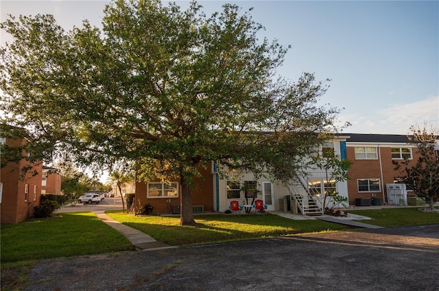 view of front of property featuring central air condition unit and a front yard