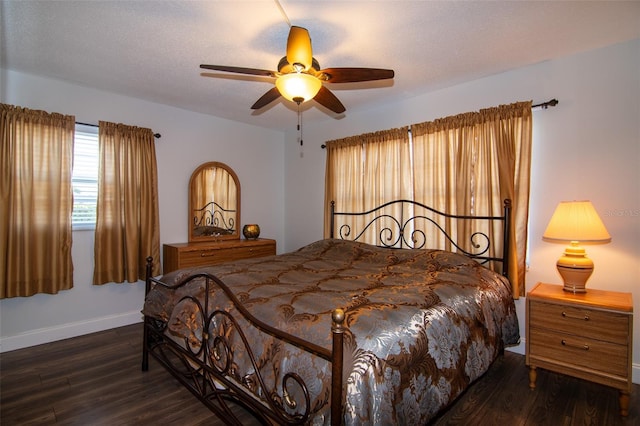 bedroom with ceiling fan, dark wood-type flooring, and a textured ceiling