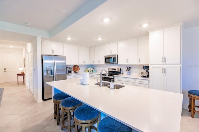 kitchen featuring sink, light tile patterned floors, white cabinetry, and stainless steel appliances