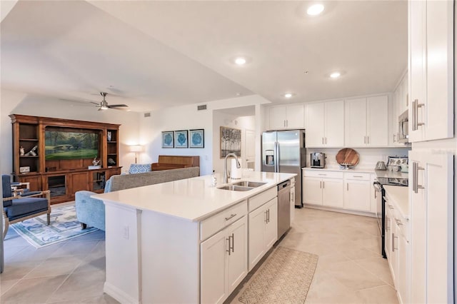 kitchen featuring ceiling fan, sink, a center island with sink, light tile patterned flooring, and stainless steel appliances