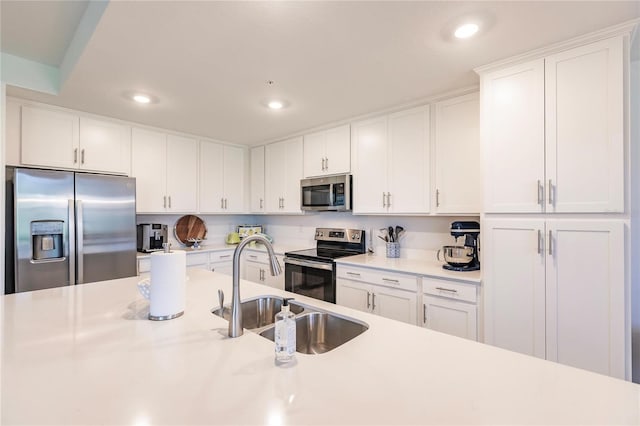 kitchen with sink, stainless steel appliances, and white cabinetry