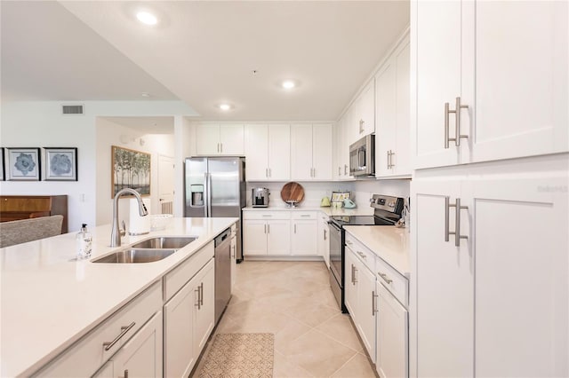 kitchen featuring sink, white cabinetry, appliances with stainless steel finishes, and light tile patterned floors